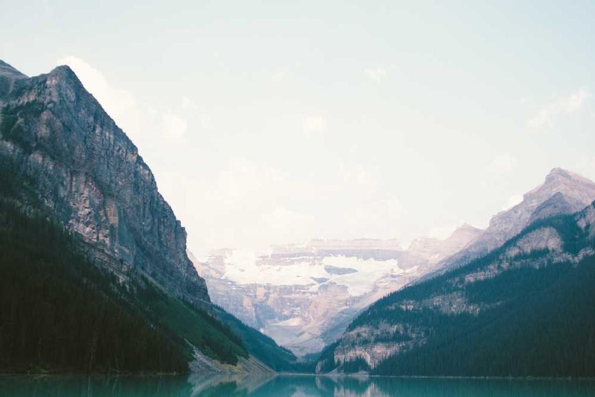 Person using foldable clothes rack in small bedroom for compact storage